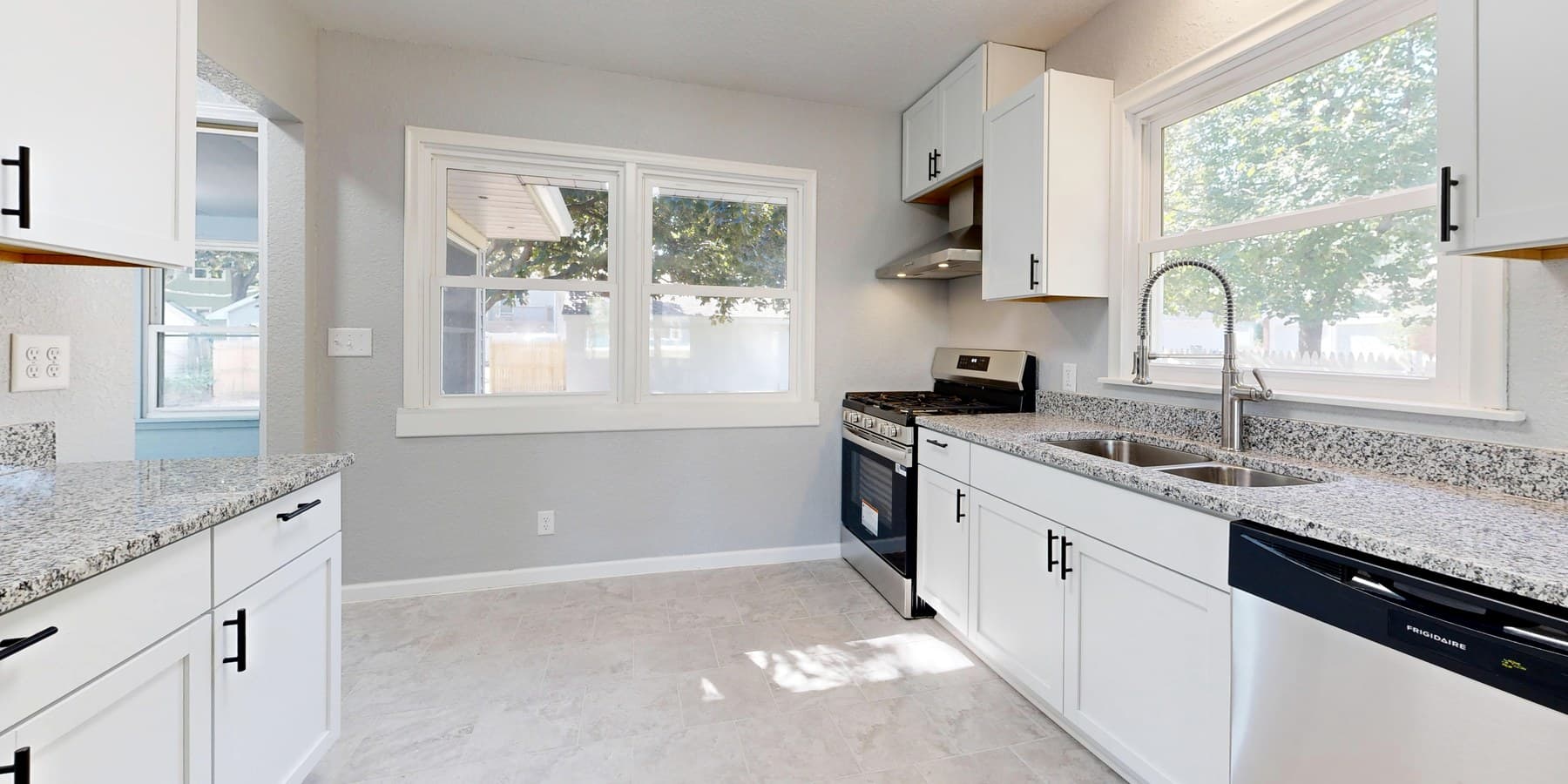 A finished kitchen remodel with granite counters in full sun