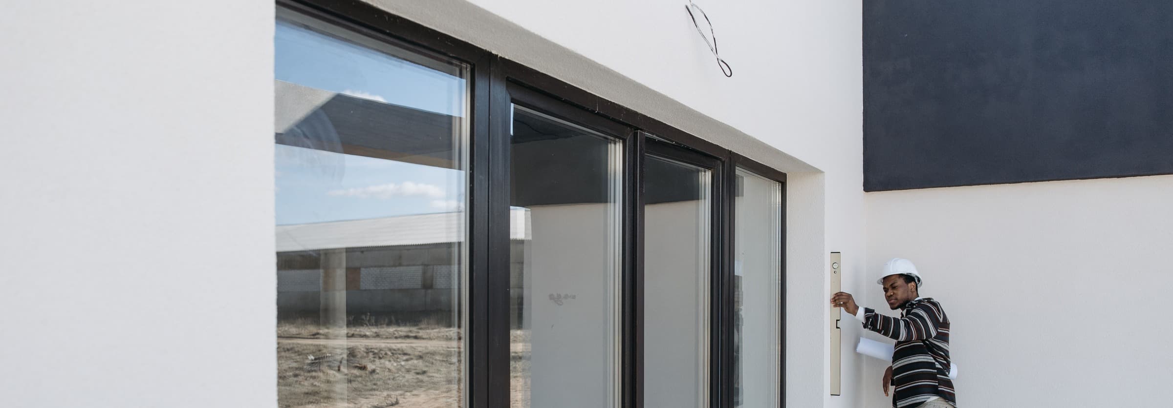 A contractor checking the frame of a new sliding glass door on a house
